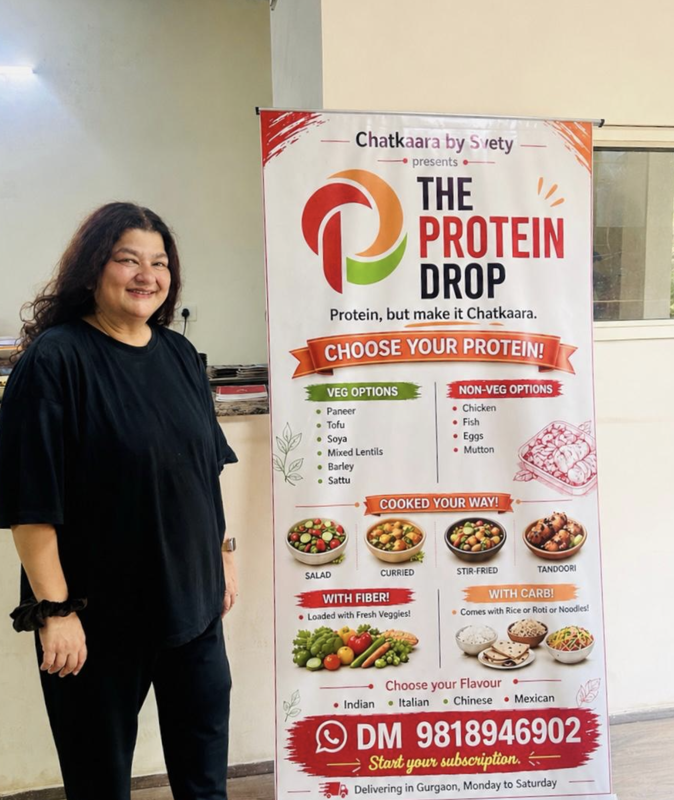 Svety standing beside The Protein Drop poster